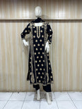 Black embroidered traditional outfit on a mannequin against a striped