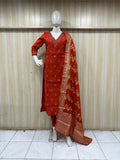 Red traditional outfit with a dupatta on a mannequin against a striped