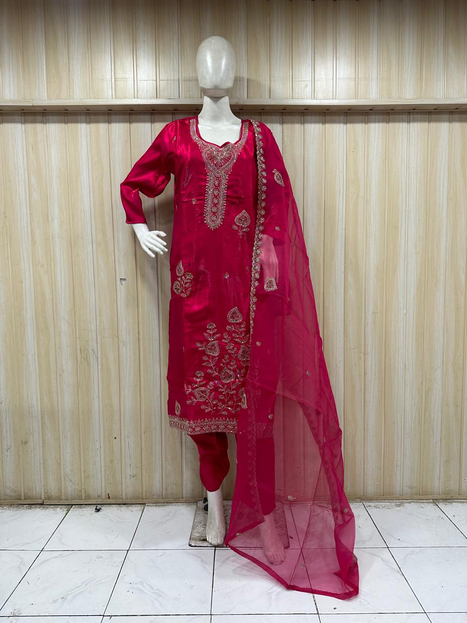 Red embroidered traditional outfit on a mannequin against a striped