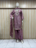 Mannequin wearing a mauve traditional outfit with intricate patterns against a striped
