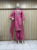 Pink traditional outfit with intricate designs on a mannequin against a striped