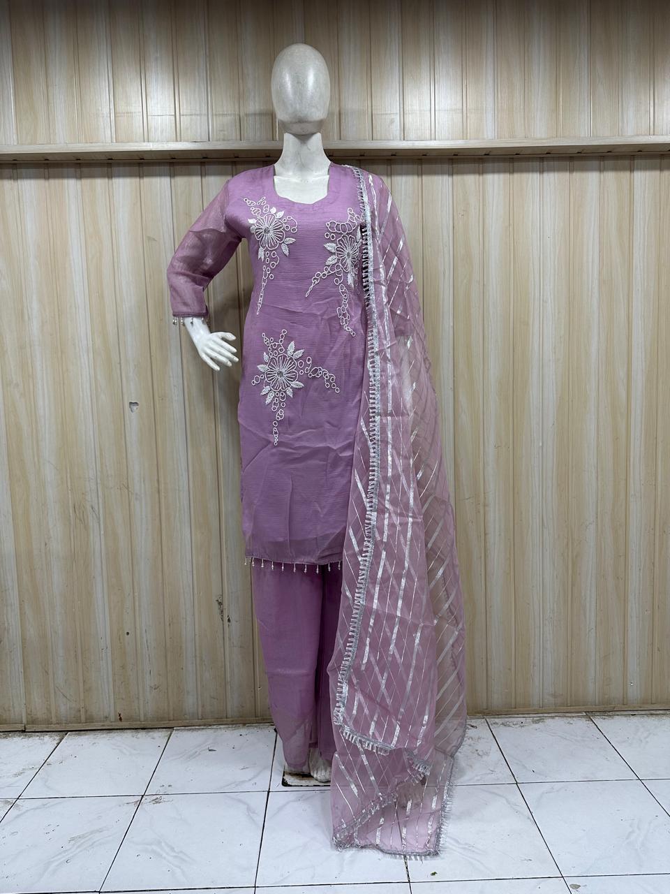 Purple traditional outfit with a dupatta on a mannequin against a striped