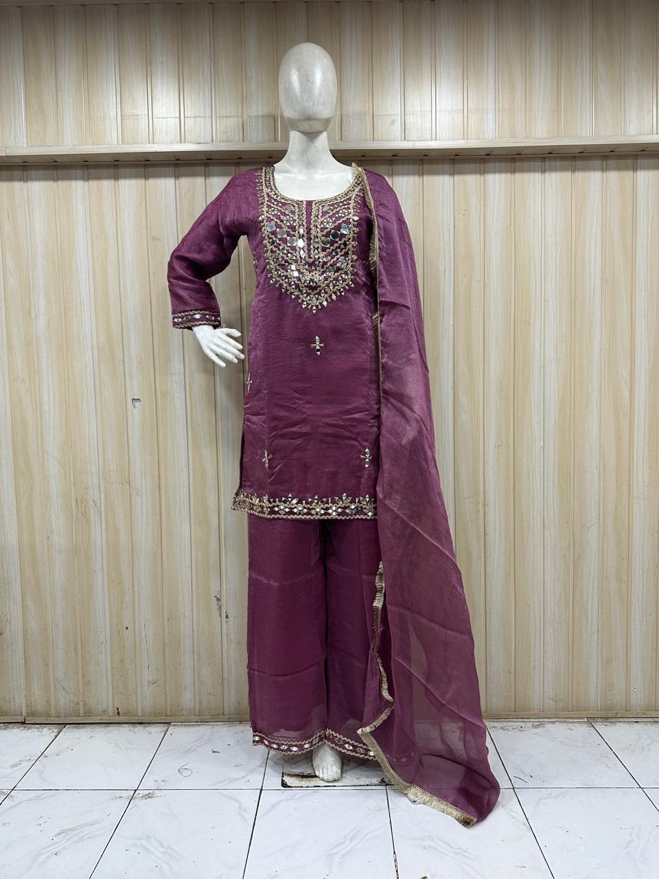 Purple traditional outfit with intricate embroidery on a mannequin against a plain background