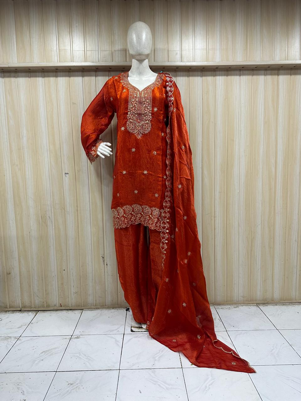 oraing traditional outfit with intricate embroidery on a mannequin against a plain background