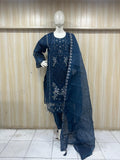 Navy blue embroidered traditional outfit on a mannequin against a wooden panel background
