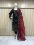 Mannequin wearing a black embroidered dress with a red dupatta against a striped