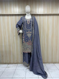 Mannequin wearing a traditional outfit with embroidered top and dark blue dupatta against a wooden panel background.