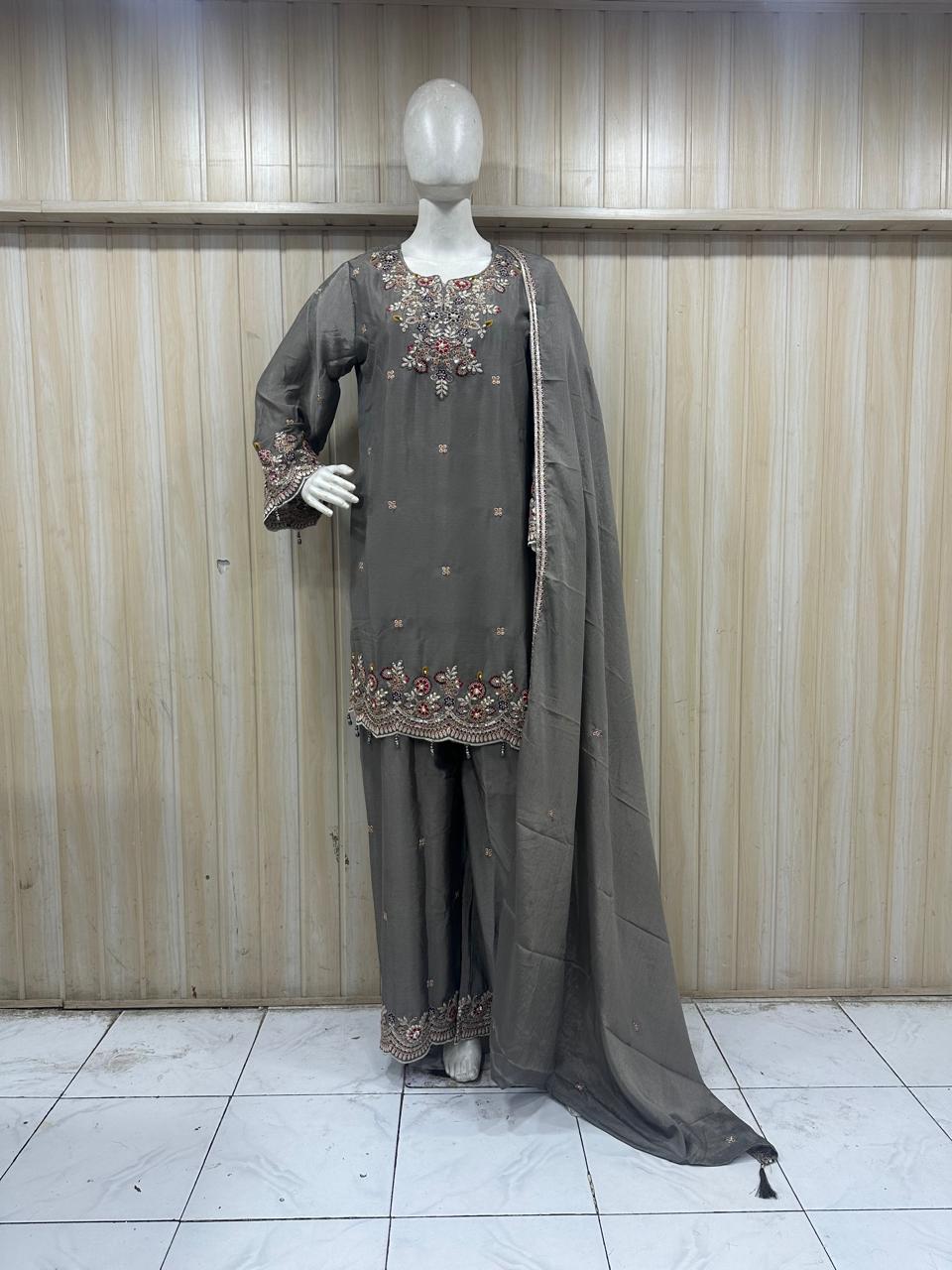 Gray embroidered outfit with a long dupatta on a mannequin against a striped