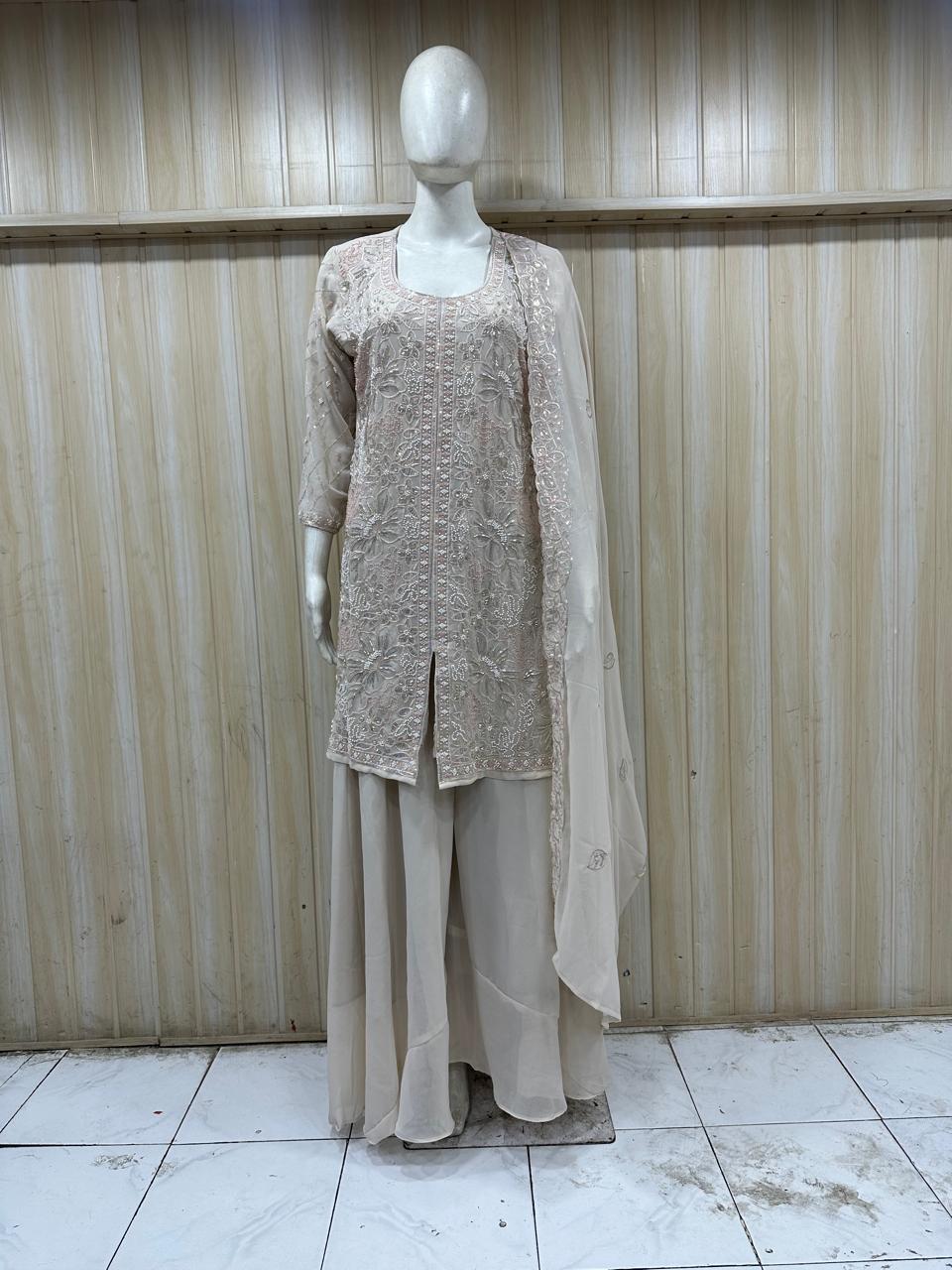 Mannequin wearing a beige outfit with a lace top and long skirt against a striped