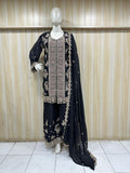 Black embroidered outfit with dupatta on a mannequin against a striped