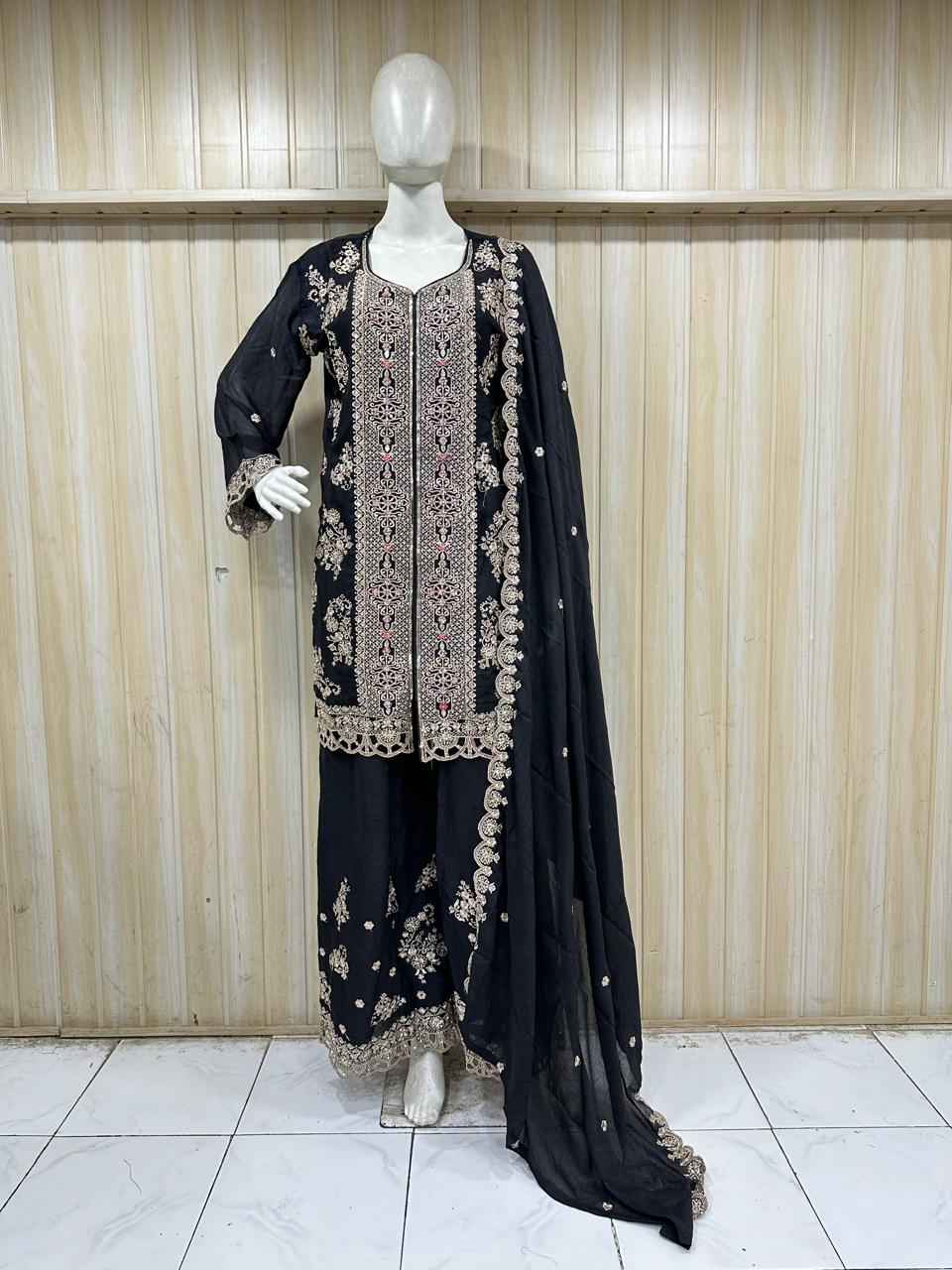 Black embroidered outfit with dupatta on a mannequin against a striped