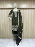 Green and black traditional outfit with white embroidery on a mannequin against a striped