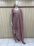 Mannequin wearing a mauve embroidered traditional outfit against a wooden panel background