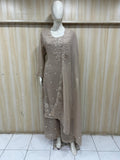 Mannequin wearing a brown traditional outfit with intricate designs against a striped