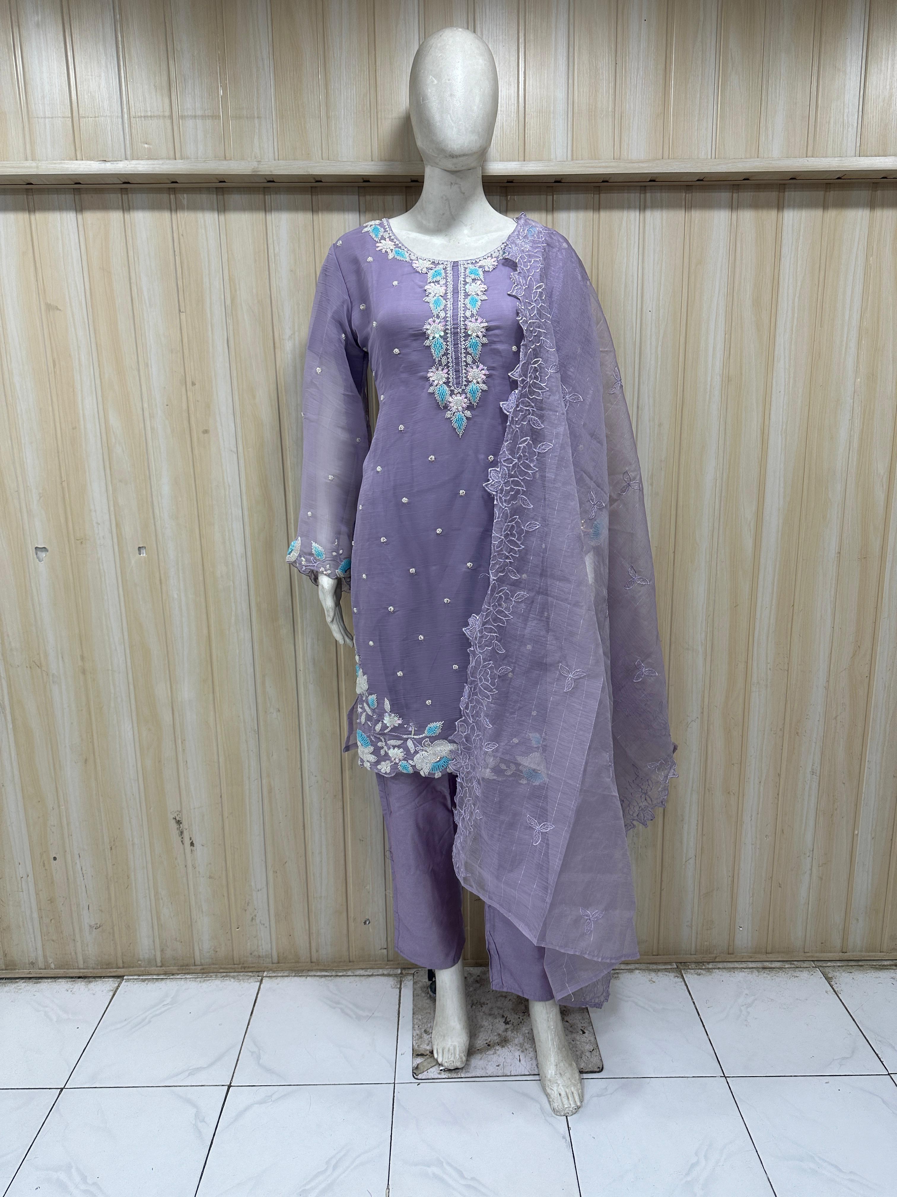 Purple embroidered outfit on a mannequin against a striped