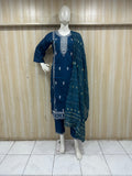 Mannequin wearing a navy blue traditional outfit with embroidery against a striped
