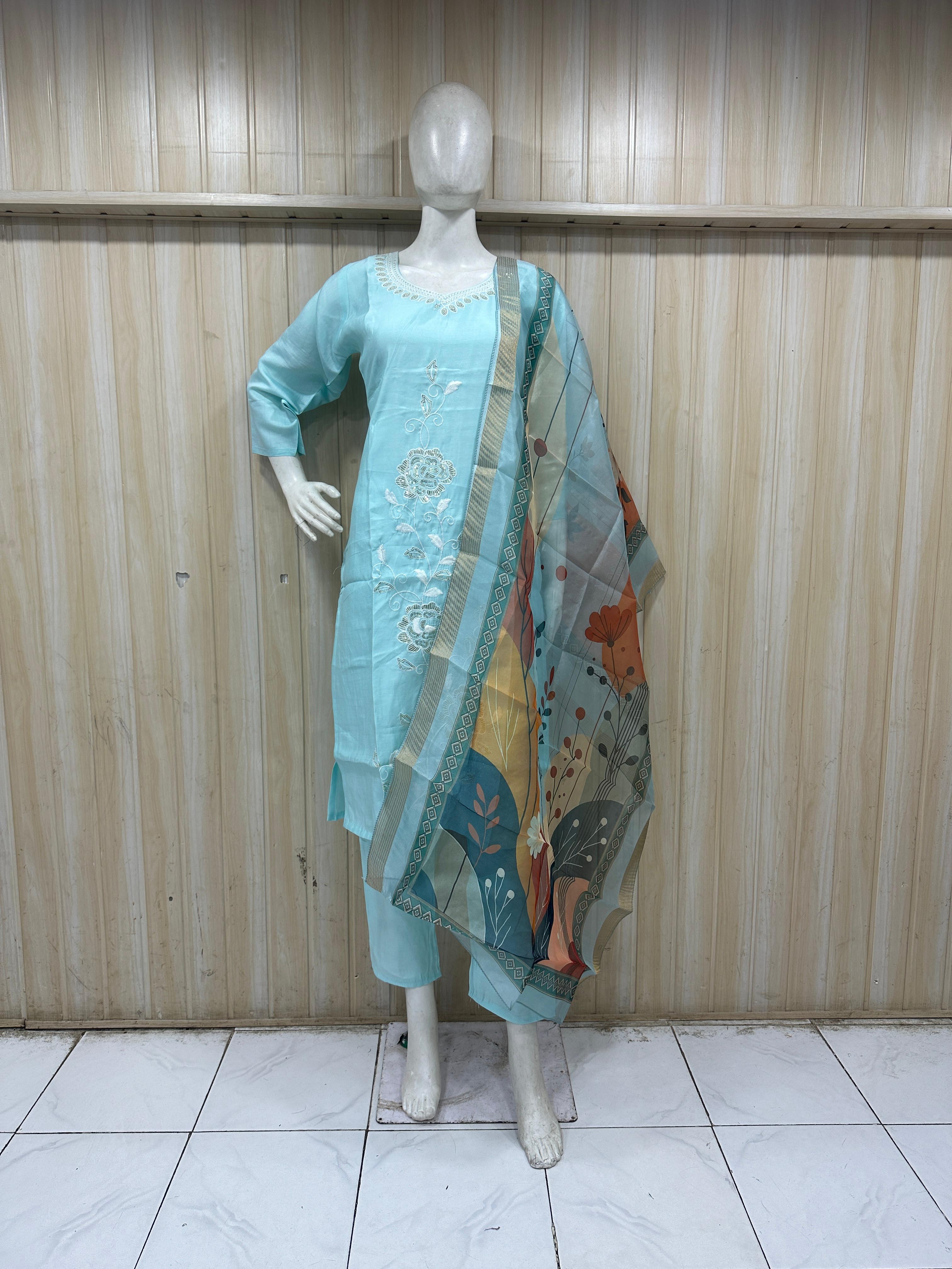 Mannequin wearing a blue traditional outfit with embroidery against a striped