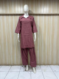 Mannequin wearing a maroon outfit against a striped