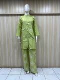 Mannequin wearing a green outfit against a wooden panel background