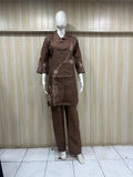 Brown outfit with floral embroidery on a mannequin against a striped