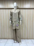 Mannequin wearing a beige embroidered outfit against a striped