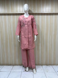 Mannequin wearing a pink traditional outfit with embroidery against a striped