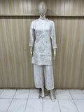 Mannequin wearing a white dress with geometric patterns against a striped