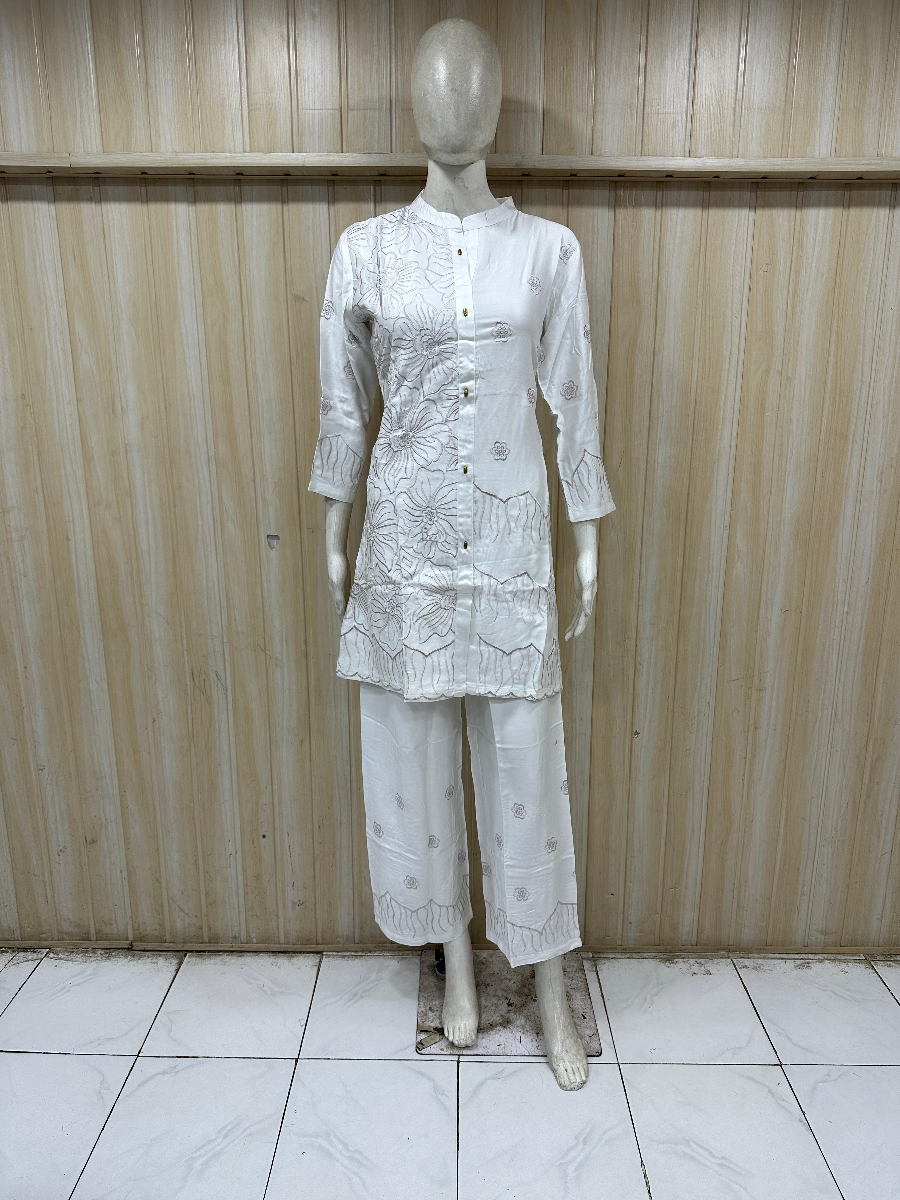 Mannequin wearing a white dress with geometric patterns against a striped