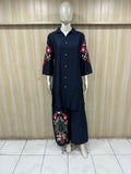 Mannequin wearing a navy blue dress with geometric patterns against a striped