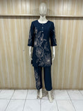 Navy blue outfit with floral embroidery on a mannequin against a wooden panel background