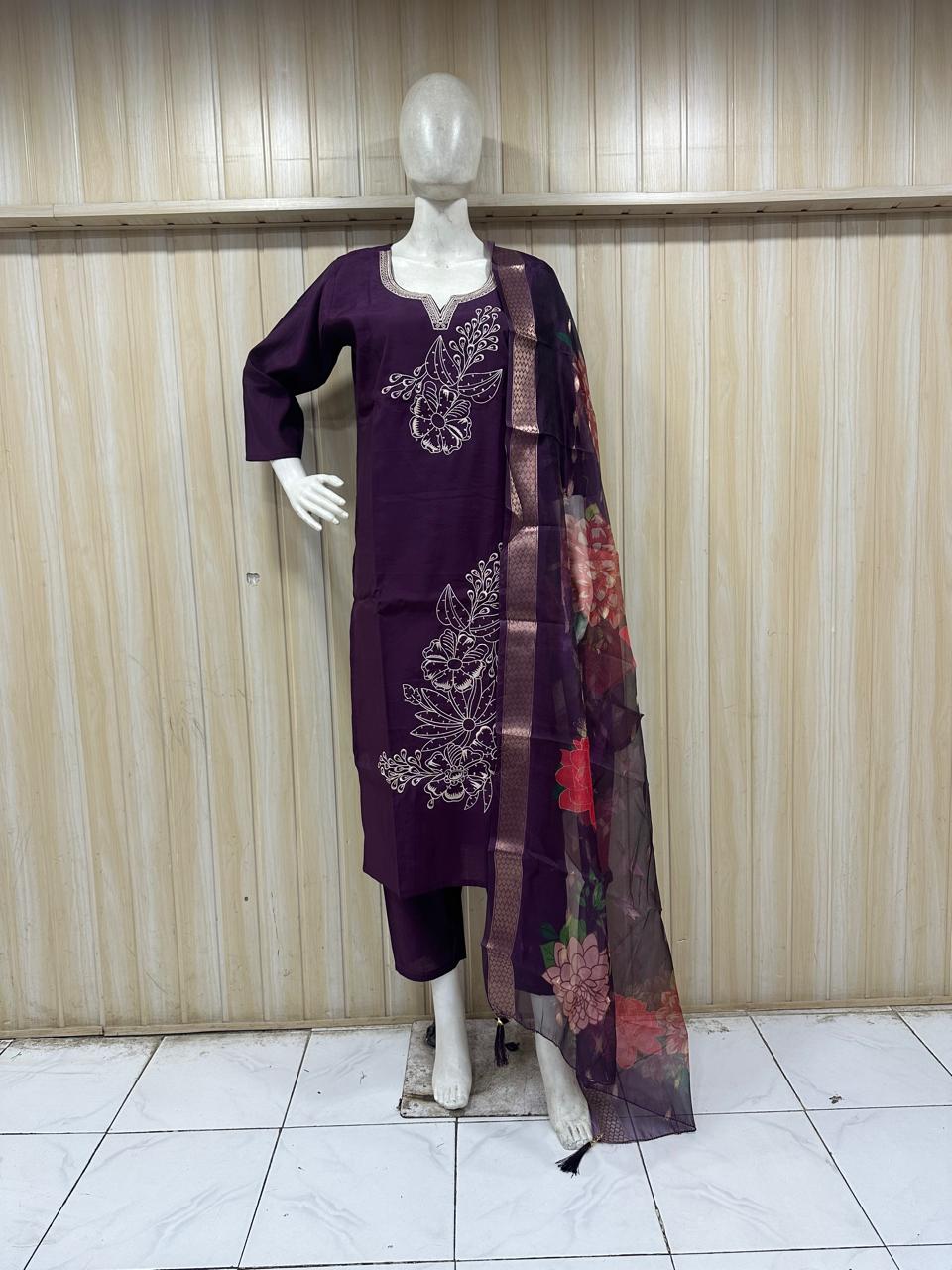 Mannequin wearing a purple dress with floral patterns against a striped