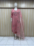 Mannequin wearing a pink embroidered dress against a striped