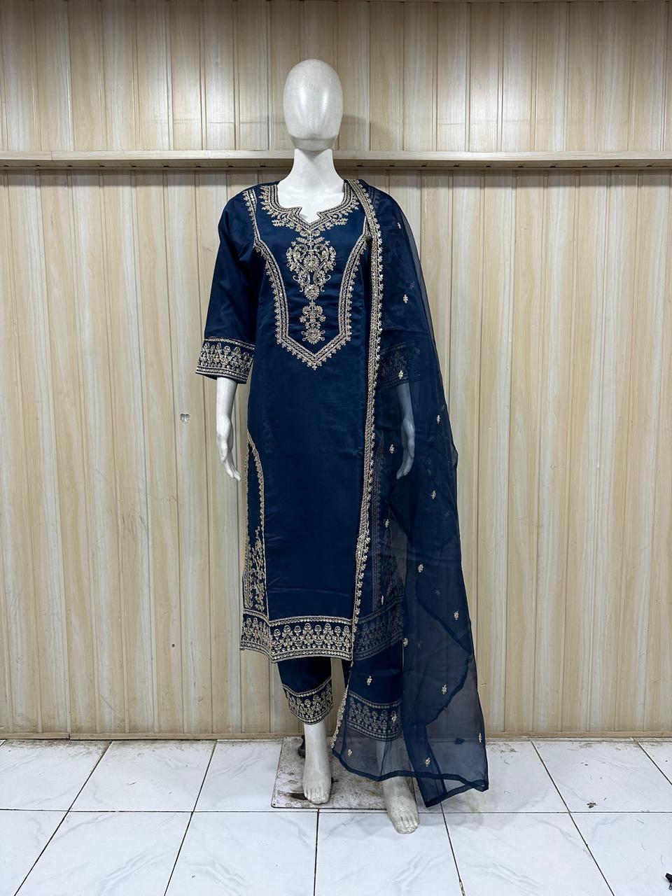 Navy blue embroidered outfit with a sheer dupatta on a mannequin against a striped