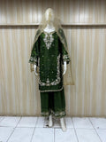 Green embroidered traditional outfit on a mannequin against a striped