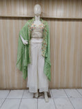 white and green embroidered outfit on a mannequin against a striped