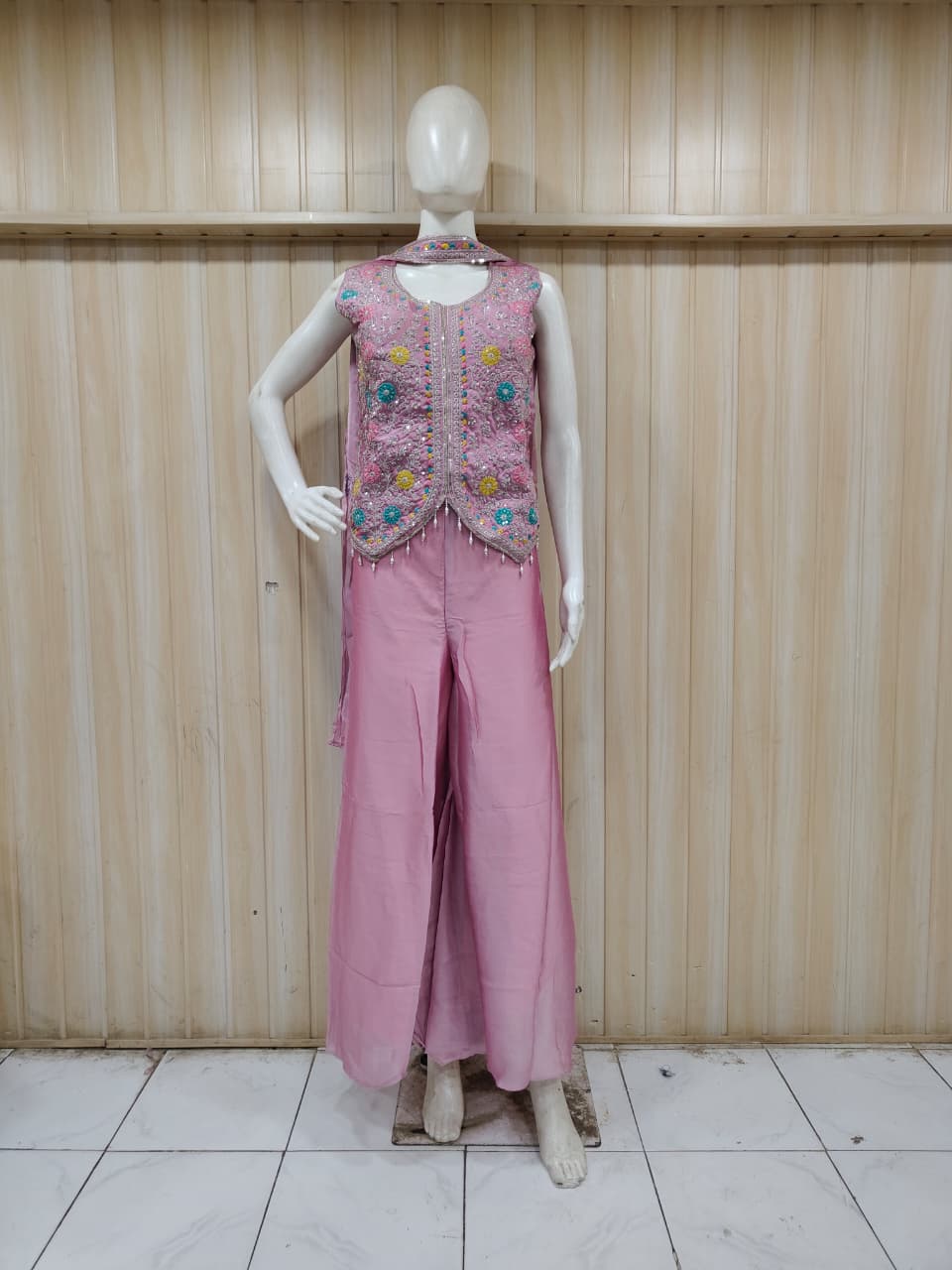 purple embroidered outfit on mannequin against striped