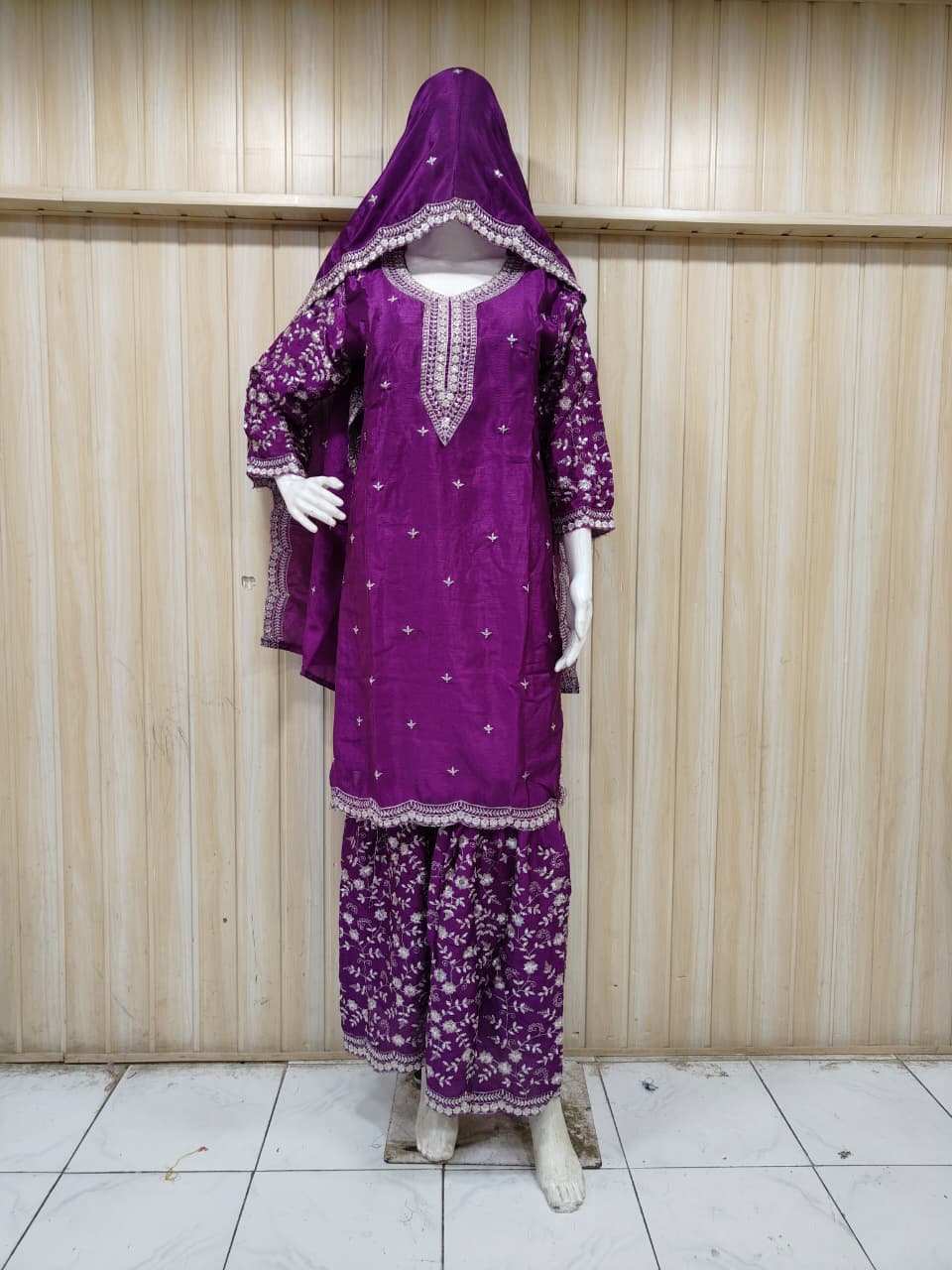 purple embroidered outfit on mannequin against striped