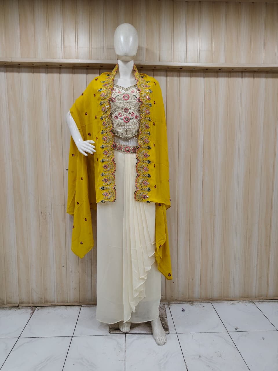 white and yellow embroidered outfit on mannequin against striped