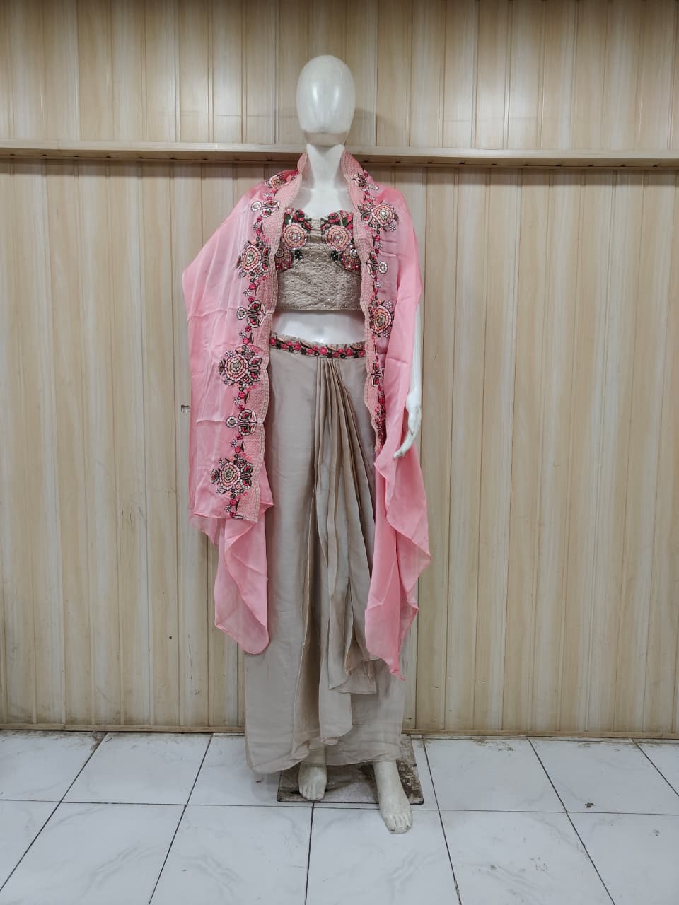 grey embroidered outfit on mannequin against striped