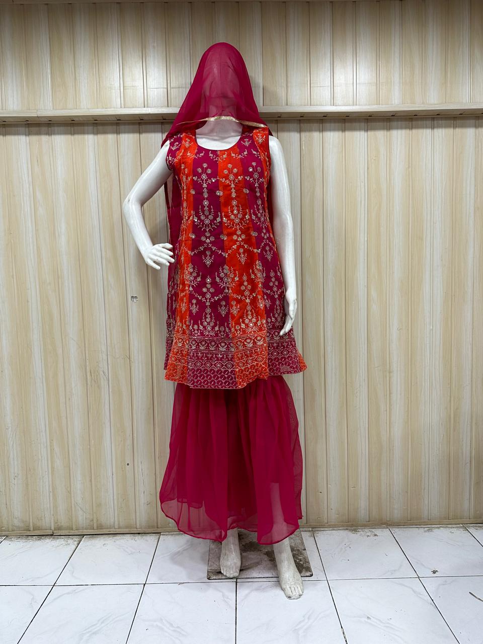 dark pink embroidered outfit on mannequin against striped