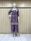 dark purple embroidered outfit on mannequin against striped