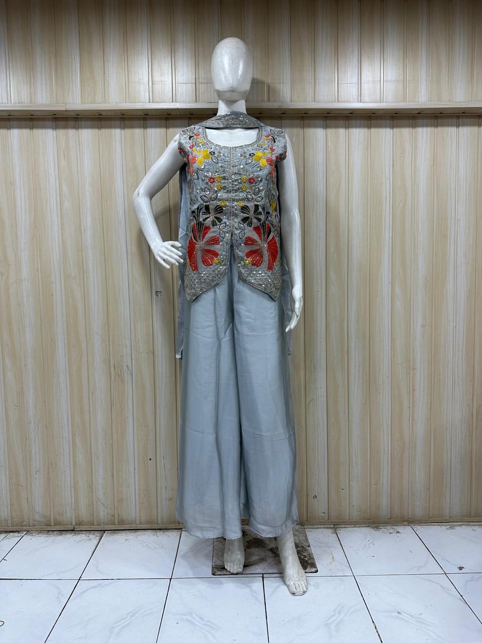 grey embroidered outfit on mannequin against striped
