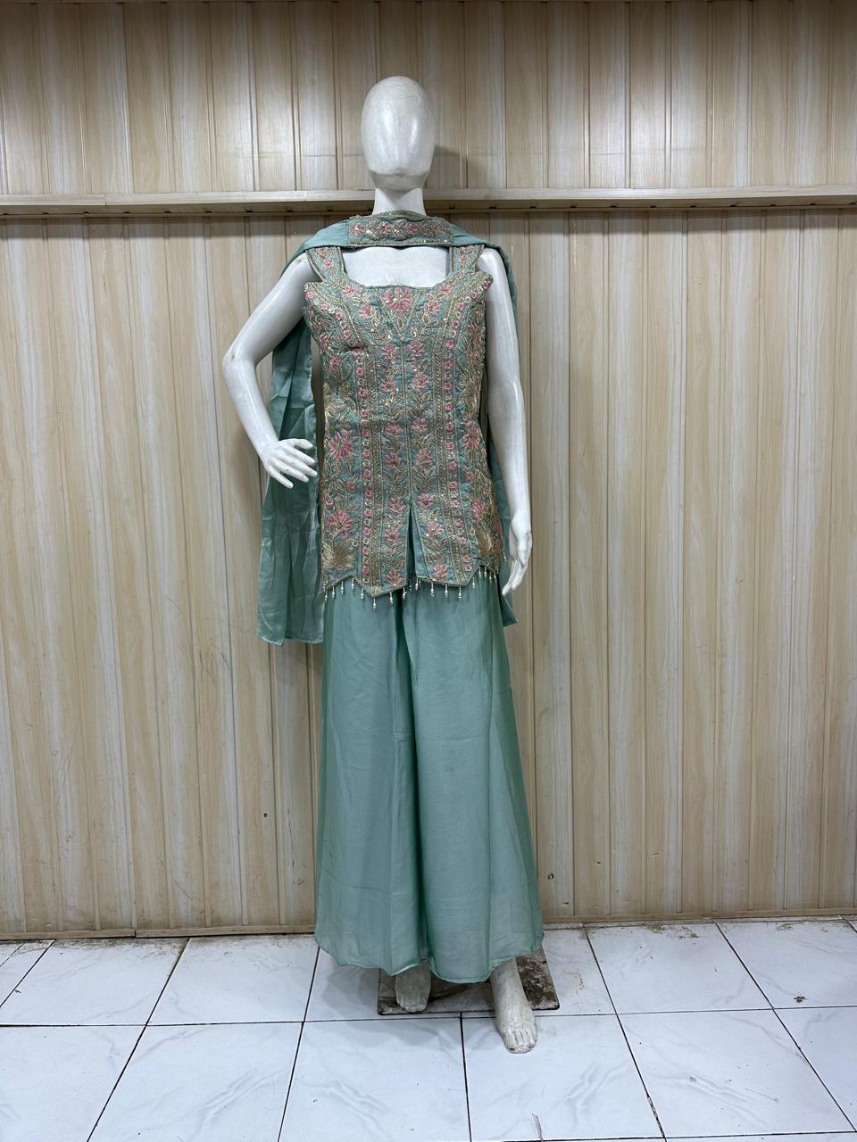Mannequin wearing a blue traditional outfit with intricate detailing against a striped