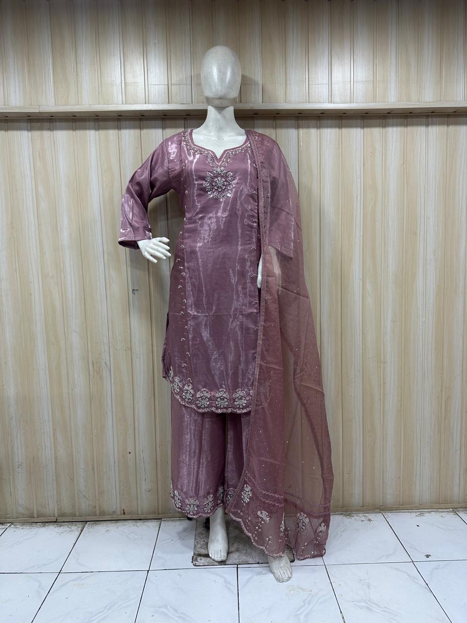 Mannequin wearing a purple traditional outfit with intricate detailing against a striped