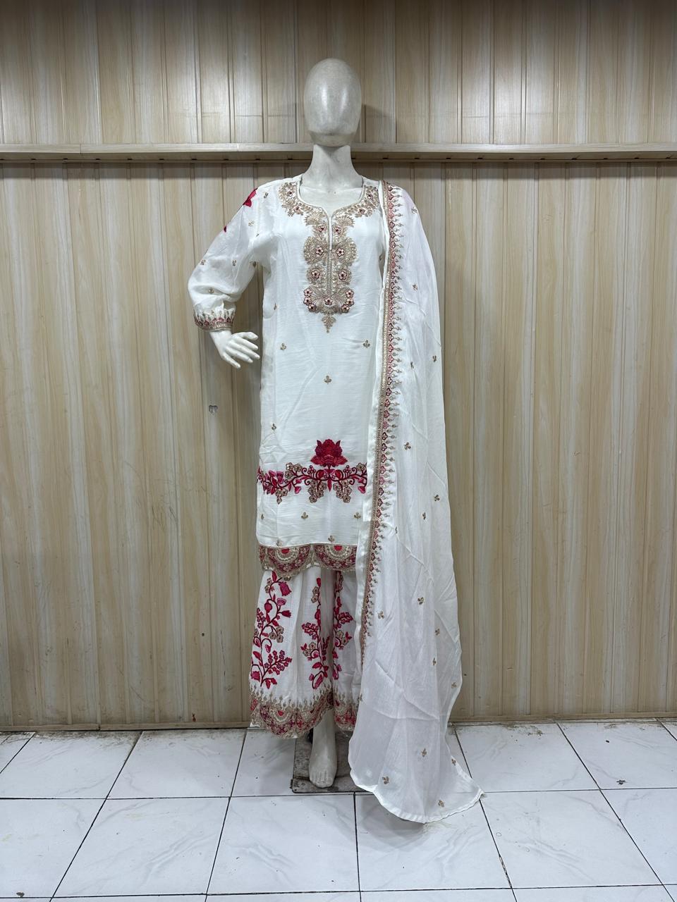 White embroidered outfit with red details on a mannequin against a striped   ChatGPT8:21 PM