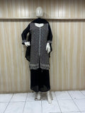 black and White embroidered outfit wit details on a mannequin against a striped