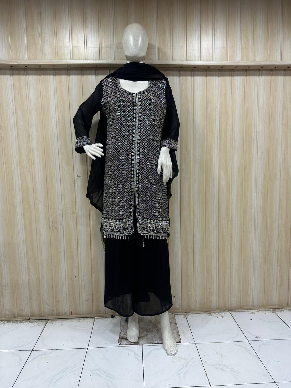black and White embroidered outfit wit details on a mannequin against a striped