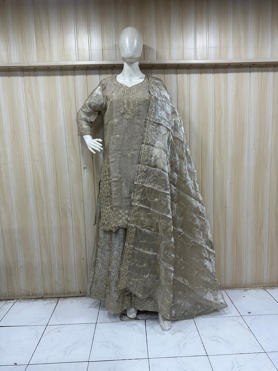 grey embroidered traditional outfit on a mannequin against a striped