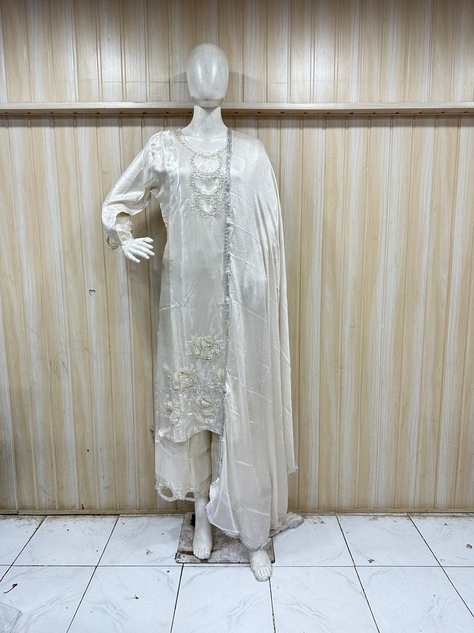 white embroidered traditional outfit on a mannequin against a striped
