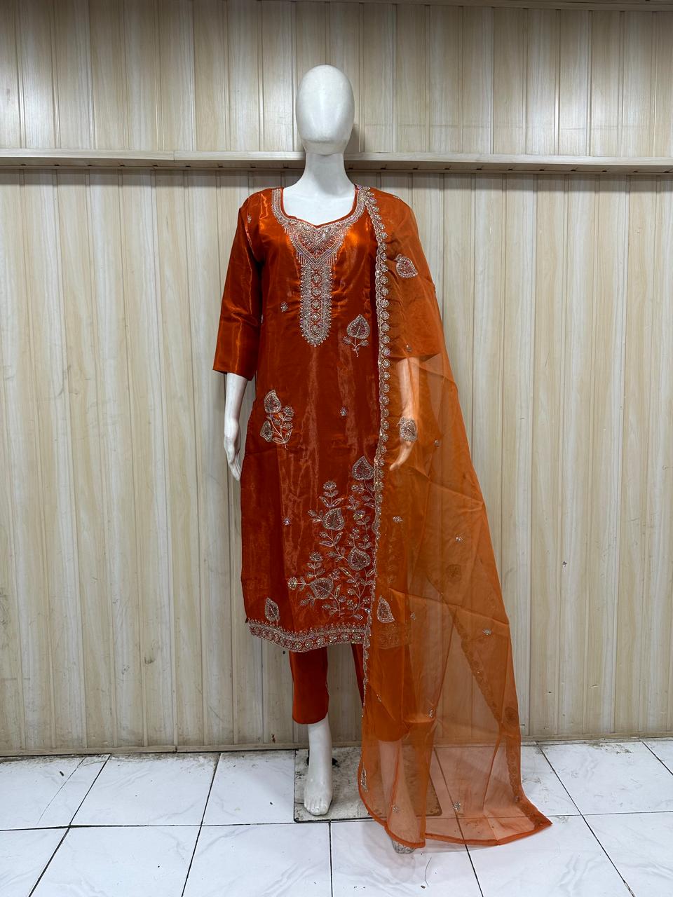 green traditional outfit with matching dupatta on a mannequin against a striped